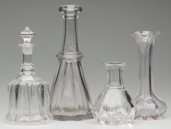 FOUR ASSORTED PILLAR-MOLDED ARTICLES: FOUR ASSORTED PILLAR-MOLDED ARTICLES, colorless, comprised of a quart bar decanter, a carafe with panel-cut neck, a bell-form pint decanter with replaced stopper, and a vase, each with eight ribs. Uni