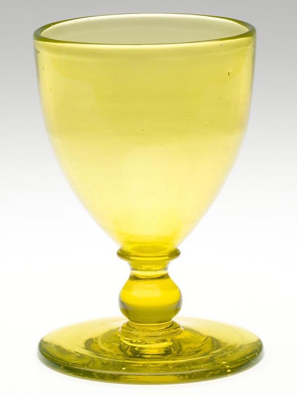 FREE-BLOWN LARGE GOBLET: FREE-BLOWN LARGE GOBLET, deep vaseline/uranium glass, funnel bowl raised on an applied knop stem and broad circular foot with rough pontil mark. Probably United States or England. 1850-1870. Height: 7