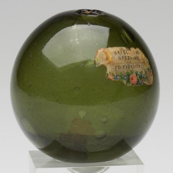 FREE-BLOWN WITCH BALL: FREE-BLOWN WITCH BALL, olive green, rough pontil mark with a 3/8 in. opening. United States, possibly Pittsburgh. 1850-1880. Diameter: 3 in. Literature: Parallels B & K III, figs. 3225-3233. Provenanc