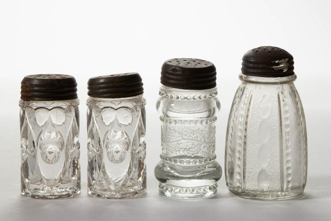 ASSORTED GREENTOWN PRESSED GLASS SALT AND PEPPER: ASSORTED GREENTOWN PRESSED GLASS SALT AND PEPPER SHAKERS, LOT OF FOUR, colorless, including two Shuttle and a Holly example, each having a period lid. Indiana Tumbler & Goblet Co. Late 19th/early 20th