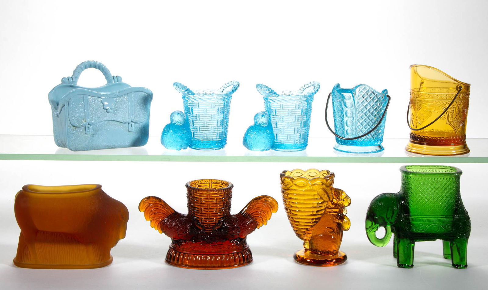 ASSORTED PRESSED NOVELTY GLASS TOOTHPICK / MATCH: ASSORTED PRESSED NOVELTY GLASS TOOTHPICK / MATCH HOLDERS, LOT OF NINE, amber, blue, green, and opaque blue, including Two Roosters, a Baby Mine, and two Coal Hod examples with metal handles. Various m