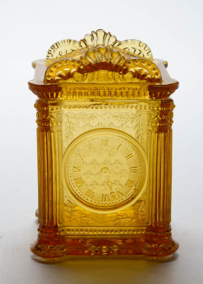 PRESSED BIG BEN CLOCK NOVELTY GLASS COVERED JAR: PRESSED BIG BEN CLOCK NOVELTY GLASS COVERED JAR, amber. Maker unverified. Fourth quarter 19th/first quarter 20th century. 4" HOA, 2 7/8" SQ.Provenance: From the Briggs - Richardson Collection, Stephen