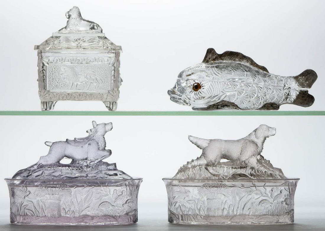 ASSORTED PRESSED NOVELTY GLASS COVERED DISHES, LOT OF: ASSORTED PRESSED NOVELTY GLASS COVERED DISHES, LOT OF FOUR, colorless, comprising a Dog with a Quail, a Deer on Fallon Tree, a Vallerysthal Fish with painted eyes, and a Laying Lion. Various makers. F