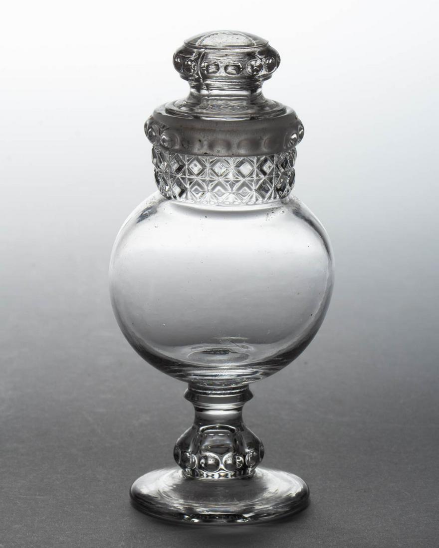 DAKOTA (OMN) CANDY CONTAINER / TOY APOTHECARY: DAKOTA (OMN) CANDY CONTAINER / TOY APOTHECARY, colorless, with original lid. Ripley & Co./U. S. Glass Co. 1885-1891. 4 3/8" HOA. Provenance: From the Lonnie Knickerbocker estate, Dansville, NY.