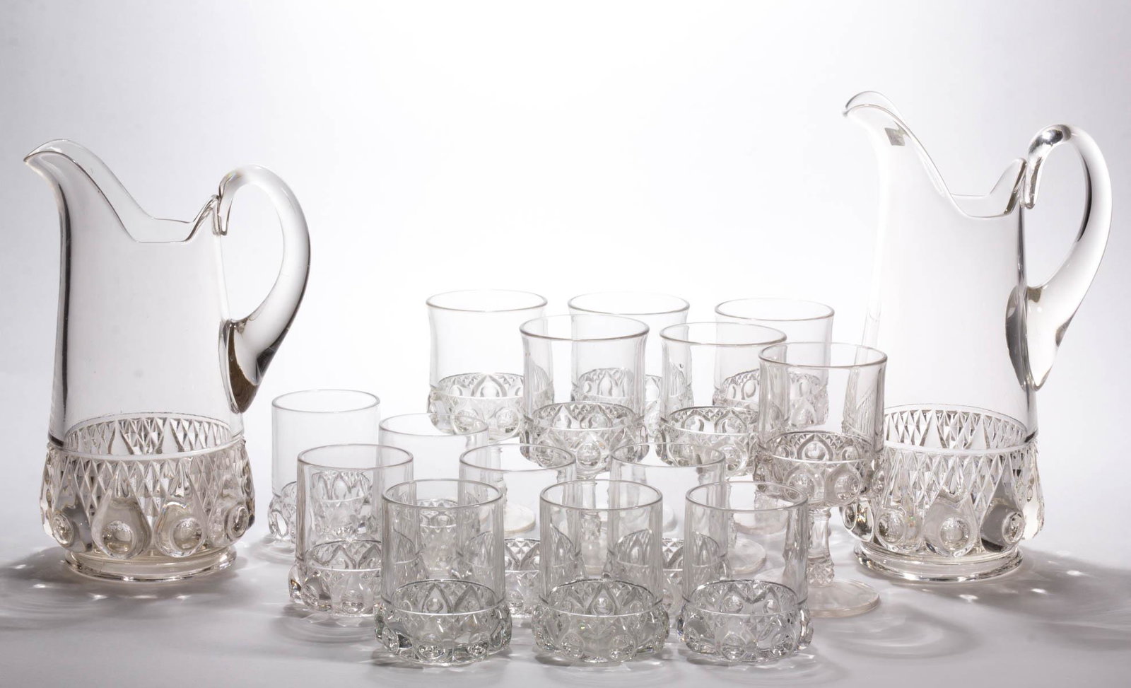 REVERSE TORPEDO DRINKING ARTICLES, LOT OF 16: REVERSE TORPEDO DRINKING ARTICLES, LOT OF 16, colorless, comprising a nine-piece water set with a tankard pitcher and tumblers, and a seven-piece water set with a tankard pitcher and goblets. Dalzell,