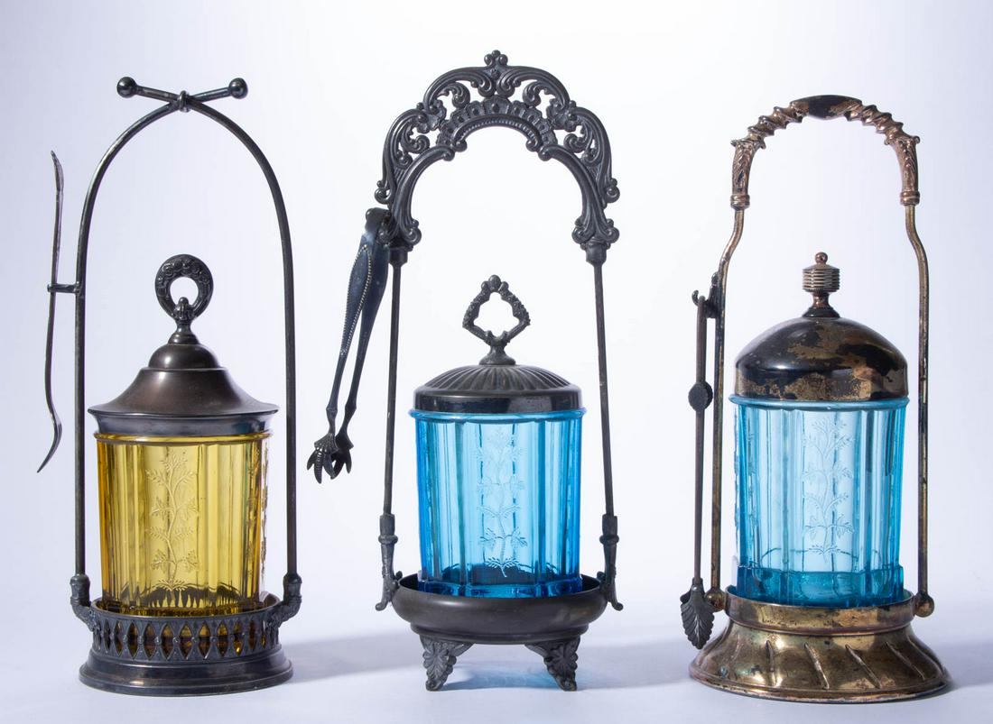 SPRIG / RIVAL (OMN) PICKLE CASTERS, LOT OF THREE: SPRIG / RIVAL (OMN) PICKLE CASTERS, LOT OF THREE, blue and amber, each fitted into a silver-plated stand and topped by a silver-plated cover, including two pairs of tongs and a pickle fork. Bryce, Hig