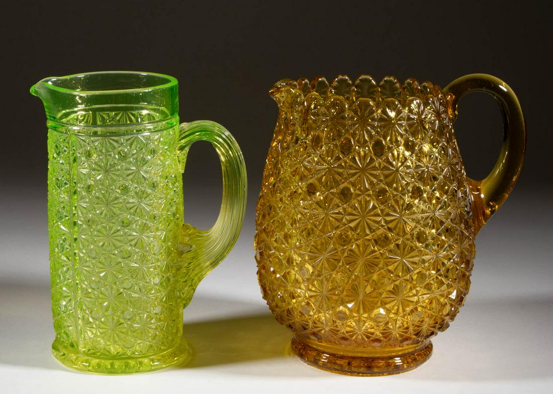 ASSORTED DAISY AND BUTTON PITCHERS, LOT OF TWO: ASSORTED DAISY AND BUTTON PITCHERS, LOT OF TWO, comprising an amber footed ovoid form, and a Panelled Vaseline (reacts under black light) example, each having an applied handle. Various makers. Fourth