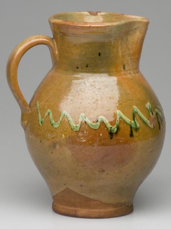 EARLY MID-ATLANTIC DECORATED EARTHENWARE / REDWARE: EARLY MID-ATLANTIC DECORATED EARTHENWARE / REDWARE OVOID PITCHER, approximately 1 gallon, lead and engobe glazed with a copper-slip trailed medial decoration, exceptionally graceful and well-potted fo