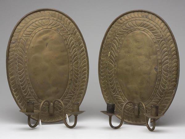 PAIR OF BRASS DOUBLE-ARM WALL SCONCES: PAIR OF BRASS DOUBLE-ARM WALL SCONCES, oval back plates embossed with hearts and plumes, each fitted with a removable double arm. Late 19th/early 20th century. 15" x 11". Provenance: Formerly in the c