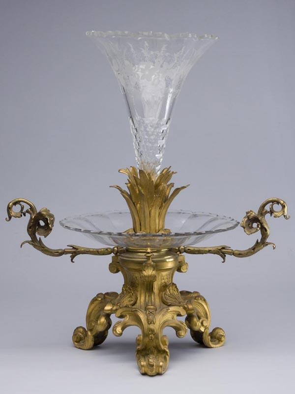 FINE CONTINENTAL GILT-BRONZE AND CRYSTAL EPERGNE: FINE CONTINENTAL GILT-BRONZE AND CRYSTAL EPERGNE, colorless cut and engraved trumpet-form center vase with a cattails lower mount, above a panel-cut shallow bowl, the whole raised on a two-handle tri-