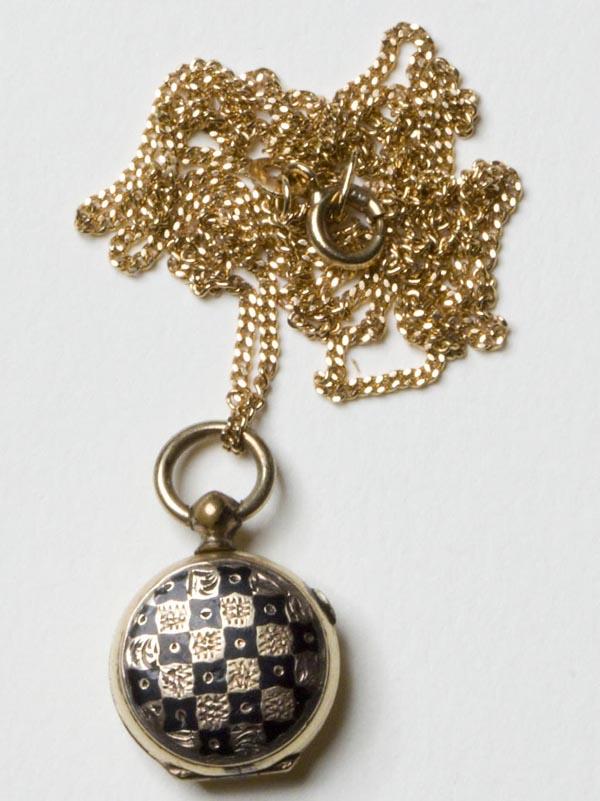 VICTORIAN HAIR-WORK MOURNING LOCKET: VICTORIAN HAIR-WORK MOURNING LOCKET, tested 9k gold, on a contemporary 18k gold chain, locket with black enamel checkerboard design on front, interior with a leaf made from two colors of hair, laid on
