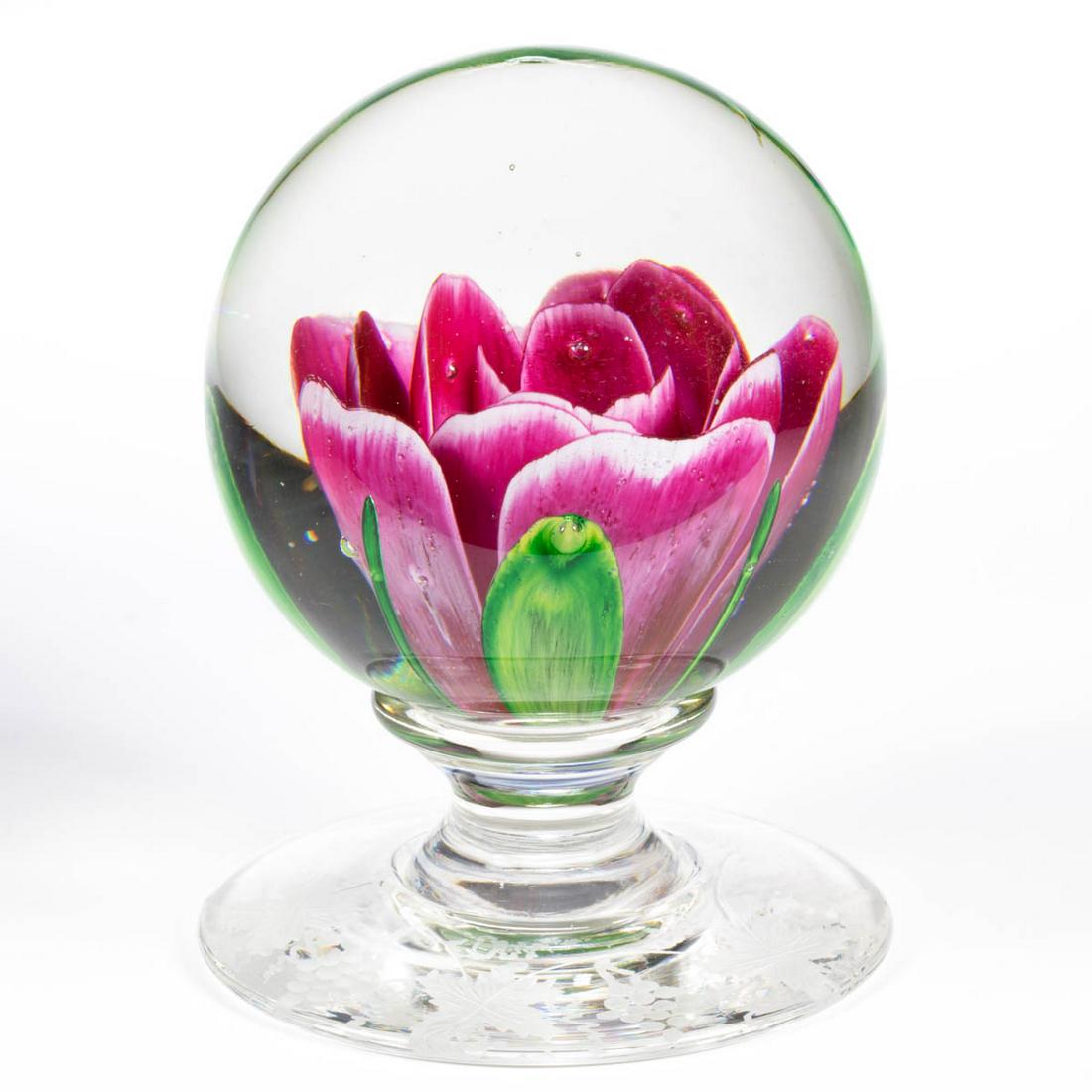 VINTAGE PAIRPOINT CRIMP ROSE - ENGRAVED ART GLASS: VINTAGE PAIRPOINT CRIMP ROSE - ENGRAVED ART GLASS PEDESTAL PAPERWEIGHT, containing a large fuchsia crimp rose with green leaves and blades protruding from the underside, applied circular foot with eng
