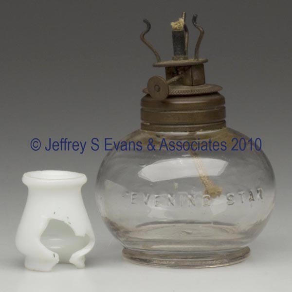 SMITH I, FIG. 12 (MIDDLE) / EVENING STAR MINIATURE: SMITH I, FIG. 12 (MIDDLE) / EVENING STAR MINIATURE FINGER LAMP, colorless, applied handle, font embossed "EVENING STAR" and base "E R & CO", opaque white chimney-shade, period string burner. 4 1/2" h 