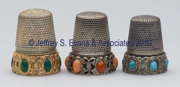 GERMAN SILVER WITH STONE THIMBLES, LOT OF THREE: GERMAN SILVER WITH STONE THIMBLES, LOT OF THREE, each with an applied scroll-work frieze band containing six set stones, consisting of coral example with various shades of stones and a scallop rim; a 