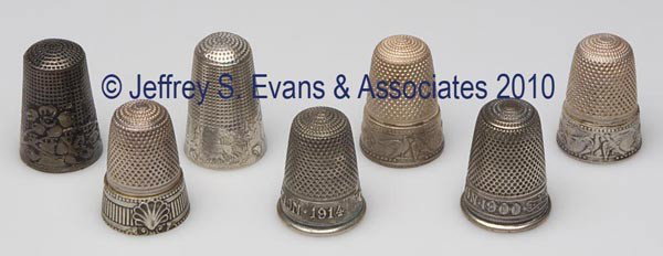 FRENCH SILVER? THIMBLES, LOT OF SEVEN: FRENCH SILVER? THIMBLES, LOT OF SEVEN, consisting of a fairy story; a floral band; two with floral band and pair doves; a "Lyon Exposition 1914"; an "Exposition 1900"; and a ribbed band with a single 