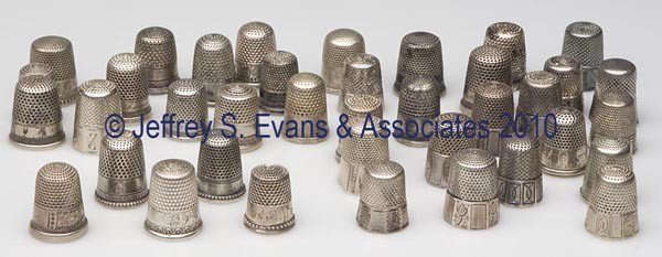 VARIOUS SILVER-LIKE THIMBLES, LOT OF 38: VARIOUS SILVER-LIKE THIMBLES, LOT OF 38, consisting of 20 utilitarian examples, 13 paneled bands, and five scenic patterns. Unmarked but probably sterling silver, 17 with monograms. Late 19th/early 20