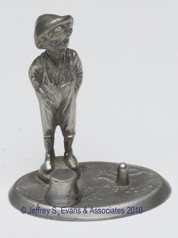 PEWTER FIGURAL THIMBLE HOLDER: PEWTER FIGURAL THIMBLE HOLDER, depicting a standing boy, underside impressed "71". Late 19th/early 20th century. 3" h overall, 1 5/8" x 2 1/2". Provenance: Collection of the late Fern I. Hill.
