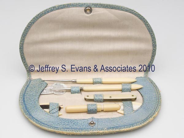 GERMAN BAKE-LITE TYPE SEWING SET: GERMAN BAKE-LITE TYPE SEWING SET, green leather case with tan silk and leather interior, stamped "GERMANY DRERES", needleworking tools include two silk winders, a crochet hook, a knife with "DPERES SO