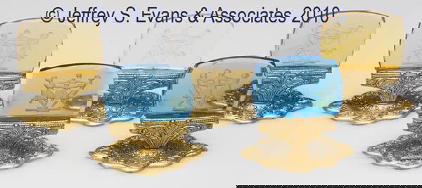 FIVE INTAGLIO GLASS PLACE CARD HOLDERS: FIVE INTAGLIO GLASS PLACE CARD HOLDERS, blue, amber and colorless, each depicting three dancing flapper girls, mounted on original gilt-metal stands. Probably Czechoslovakia. First quarter 20th centur