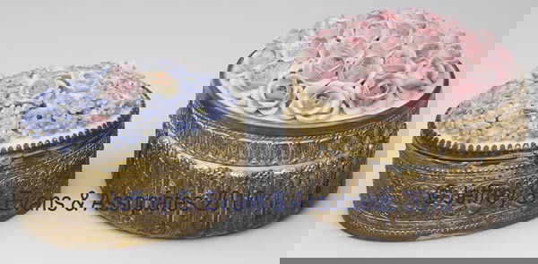 TWO CONTINENTAL PORCELAIN AND GILT-BRASS DRESSER B: TWO CONTINENTAL PORCELAIN AND GILT-BRASS DRESSER BOXES, each with applied floral ornamentations to lid, oval example with fabric-lined interior and marked Germany under base, circular example with flo