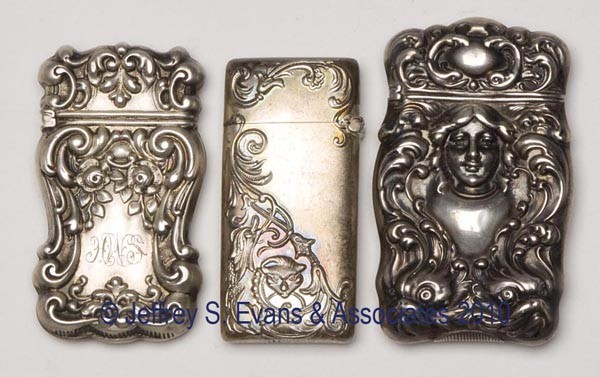 THREE STERLING SILVER HINGED-TOP MATCH SAFES: THREE STERLING SILVER HINGED-TOP MATCH SAFES, each marked and with striker, including one Art Nouveau example with female head and dolphins, one monogrammed. Late 19th/early 20th century. 2 1/4" x 1 1