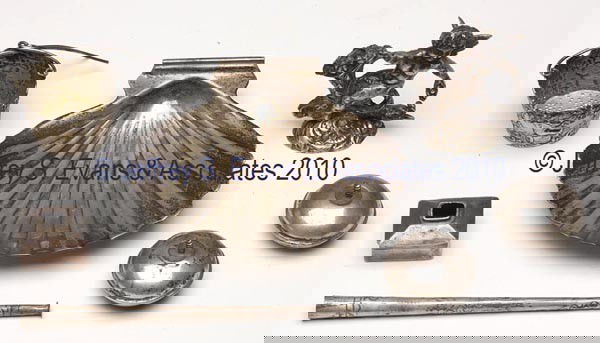 SEVEN ASSORTED SILVER AND SILVER-LIKE ARTICLES: SEVEN ASSORTED SILVER AND SILVER-LIKE ARTICLES, shell, cigar holder, and two bun feet marked sterling, tea strainer and cherub-form flower holder with unidentified hallmarks. 20th century. Cherub 2 1/