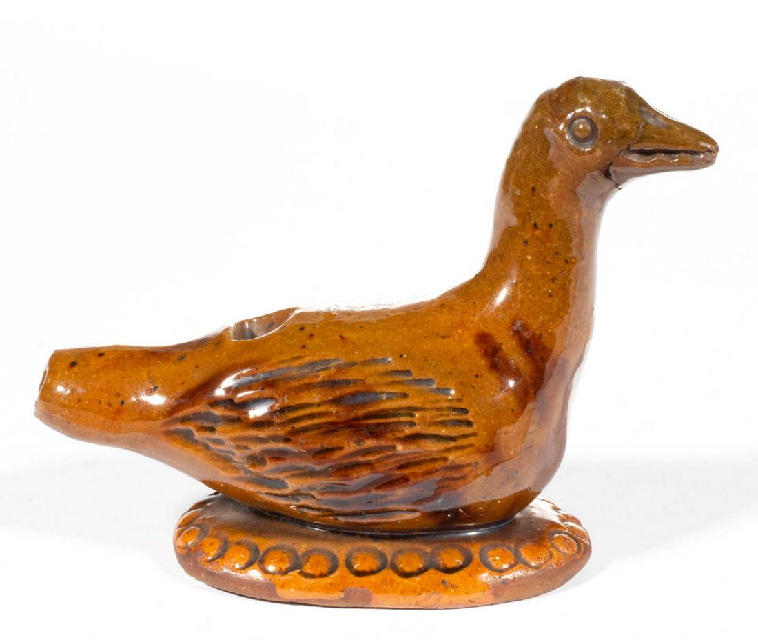 PENNSYLVANIA EARTHENWARE / REDWARE FIGURAL BIRD WHISTLE: PENNSYLVANIA EARTHENWARE / REDWARE FIGURAL BIRD WHISTLE, lead-glazed, hand-formed with punched eyes and incised features, hole to back and end of tail, resting on an ovoid base with chain-style stampe