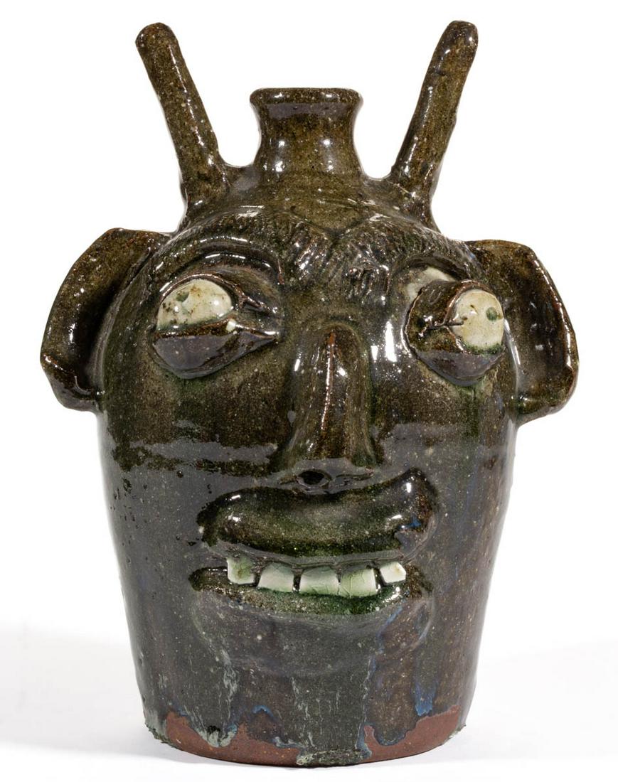 SIGNED "B.B. CRAIG" (1914-2002), VALE, NORTH CAROLINA: SIGNED "B.B. CRAIG" (1914-2002), VALE, NORTH CAROLINA STONEWARE DEVIL FACE JUG, alkaline-glazed, featuring molded eyebrows, clay eyes with black pupils, nose, lips framing five china teeth, protruding