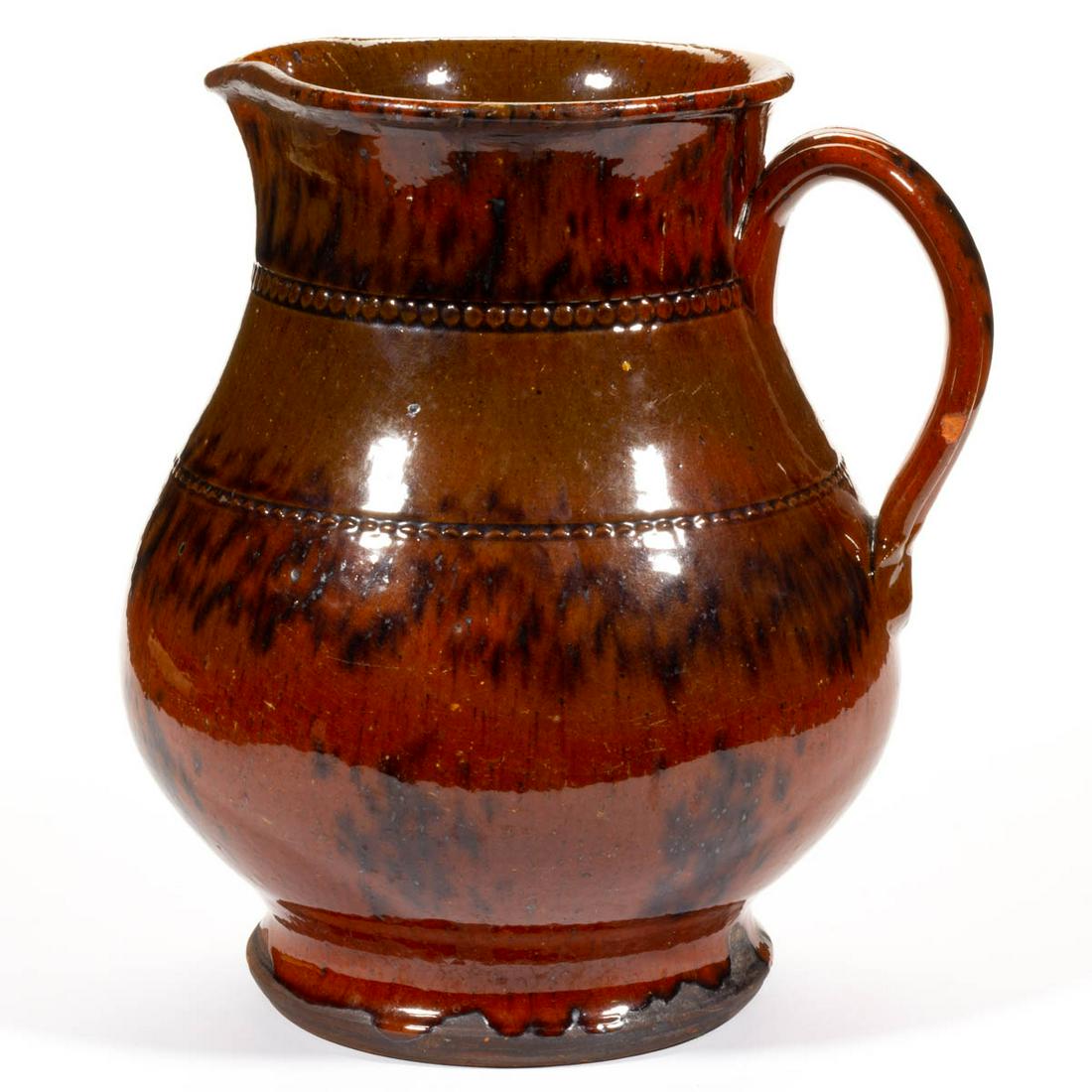 JACOB MEDINGER (1856-1932), MONTGOMERY CO.,: JACOB MEDINGER (1856-1932), MONTGOMERY CO., PENNSYLVANIA EARTHENWARE / REDWARE PITCHER, lead-glazed with manganese splashed decoration, bold baluster form with beaded shoulder and neck rings, delicate