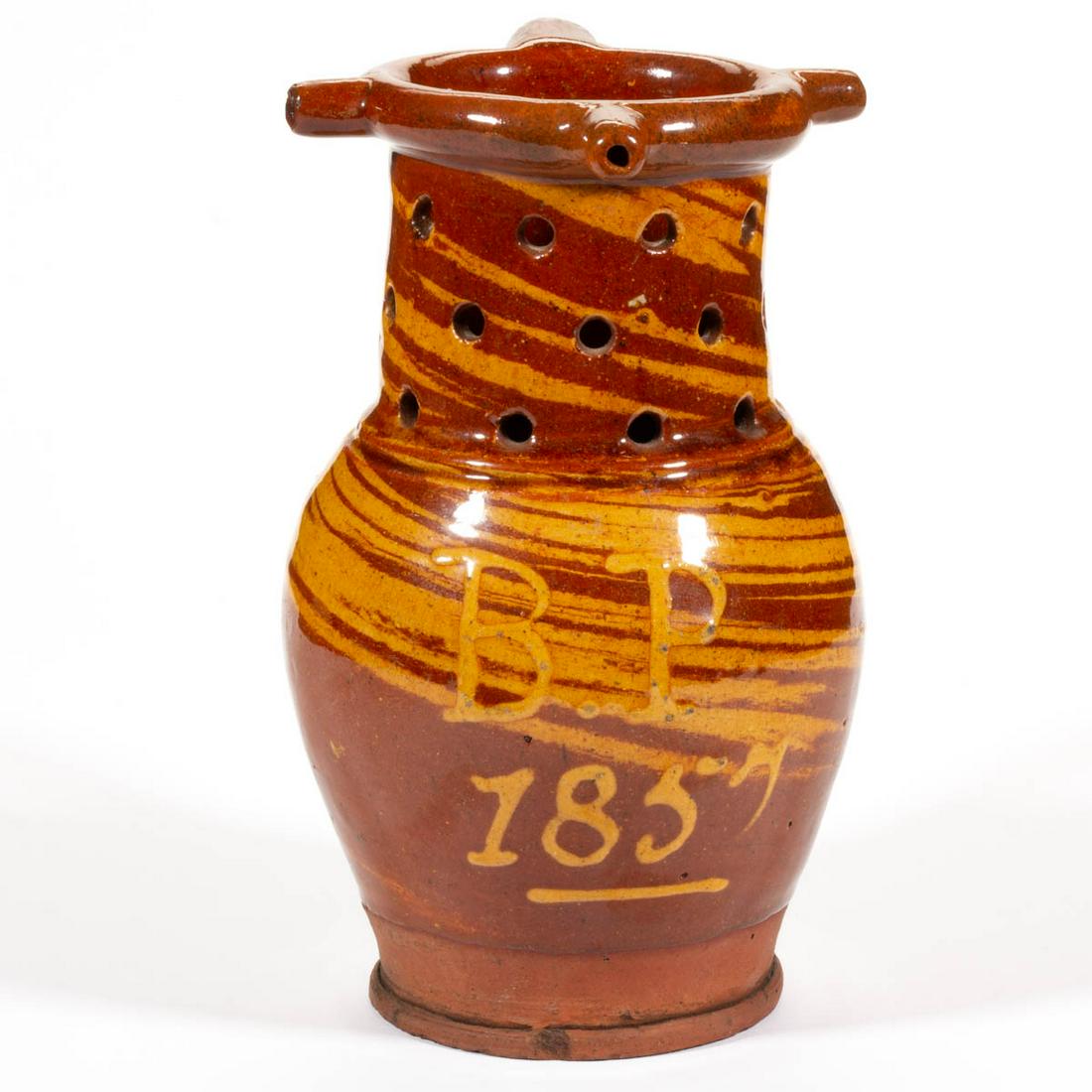 ENGLISH DECORATED EARTHENWARE / REDWARE DIMINUTIVE: ENGLISH DECORATED EARTHENWARE / REDWARE DIMINUTIVE PUZZLE JUG, ovoid body with cylindrical pierced neck, rounded hollow rim with three spouts, and rounded handle, raised on a pronounced foot. Swirling