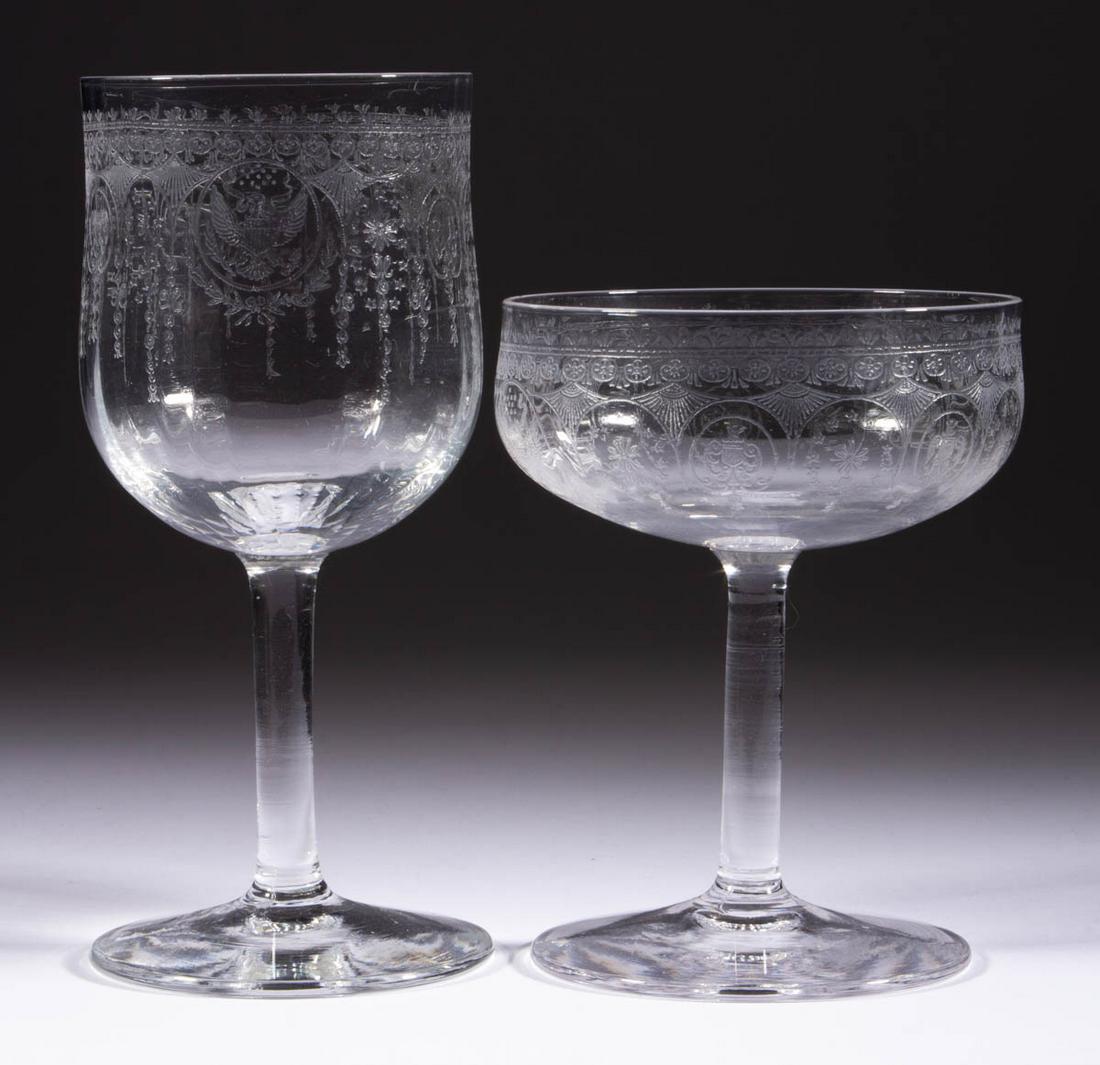 THEODORE ROOSEVELT PRESIDENTIAL ETCHED CRYSTAL GOBLET: THEODORE ROOSEVELT PRESIDENTIAL ETCHED CRYSTAL GOBLET AND CHAMPAGNE GLASS, colorless, each bowl etched with the Great Seal of the United States within a decorative band, raised on a plain stem and foo