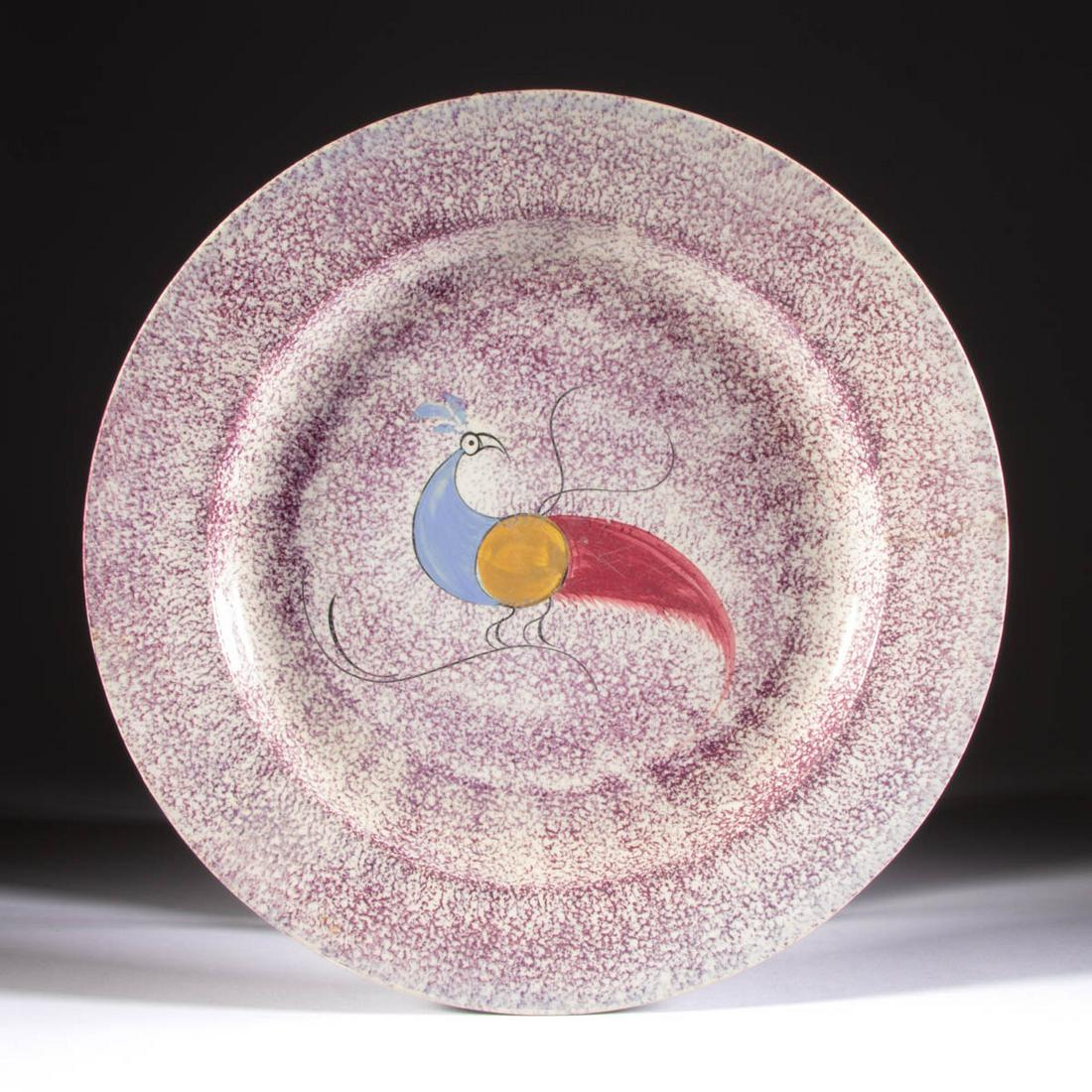 ENGLISH SPATTERWARE PEAFOWL CERAMIC PLATE: ENGLISH SPATTERWARE PEAFOWL CERAMIC PLATE, featuring a polychrome hand-painted bird perched on a branch with all over purple-sponged decoration. Unmarked. Second quarter 19th century. 9 3/8" D.Provena
