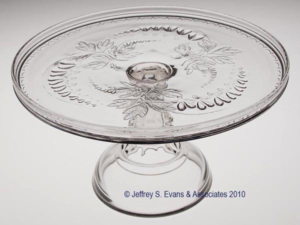 BLEEDING HEART CAKE STAND: BLEEDING HEART CAKE STAND, colorless, wafer construction. 5 1/2" h, 9 5/8" dia. Provenance: From a Vermont collection.