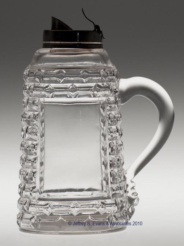 CENTRAL NO. 870 / BRICK WINDOW SYRUP PITCHER: CENTRAL NO. 870 / BRICK WINDOW SYRUP PITCHER, colorless, applied handle, period collar missing hinged top. 6" h to top of collar, 3 1/4" dia base.Provenance: From the estate of Olive Alder.