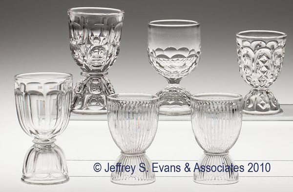 VARIOUS EAPG DOUBLE EGG CUPS, LOT OF SIX: VARIOUS EAPG DOUBLE EGG CUPS, LOT OF SIX, colorless flint, including an unknown example with alternating vertical panels of diamonds and punties, together with five others. 3 5/8" to 4 5/8" h. Provena