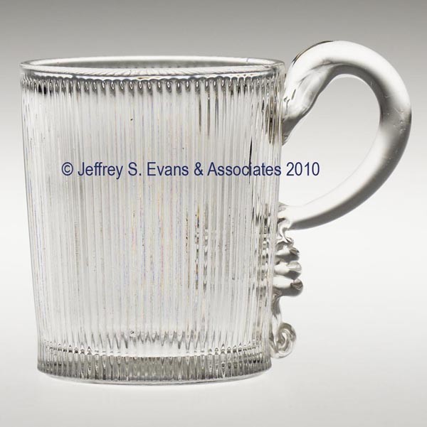 FINE RIB LEMONADE / HANDLED WHISKEY TUMBLER: FINE RIB LEMONADE / HANDLED WHISKEY TUMBLER, colorless flint, polished pontil mark. 3 1/4" h overall, 2 1/2" dia rim. Provenance: From the estate of Olive Alder.