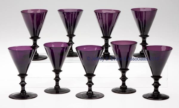SET OF NINE FREE-BLOWN WINE GLASSES: SET OF NINE FREE-BLOWN WINE GLASSES, medium amethyst, each featuring a conical-form bowl raised on an applied button stem and circular foot with a polished pontil mark. Probably England. 19th century.