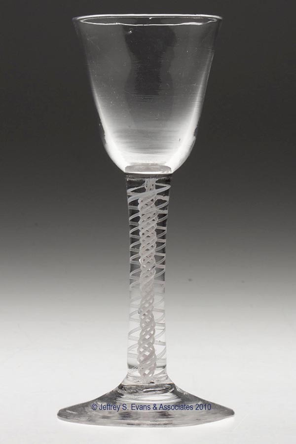 FREE-BLOWN OPAQUE-TWIST STEM WINE GLASS: FREE-BLOWN OPAQUE-TWIST STEM WINE GLASS, colorless, round funnel bowl raised on an applied stem containing a 4-ply spiral band outside 4-ply column, slightly conical foot with a rough pontil mark. Pro