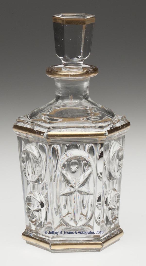 PRESSED STAR AND PUNTY COLOGNE BOTTLE: PRESSED STAR AND PUNTY COLOGNE BOTTLE, colorless with gilt banding, small-size hexagonal form produced from the same mold as the stand lamp small font, polished pontil mark, probably original panel-cu