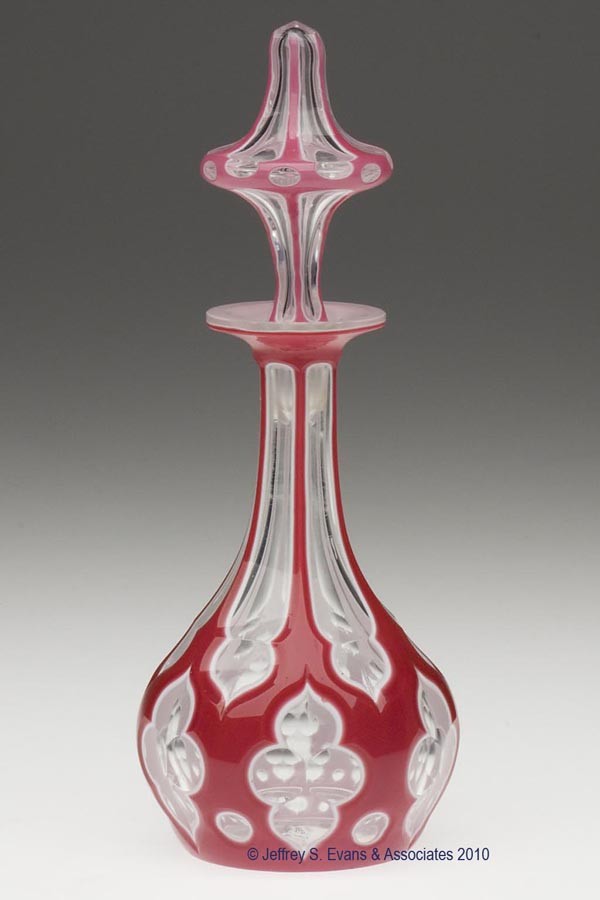 CUT DOUBLE OVERLAY MOORISH WINDOW COLOGNE BOTTLE: CUT DOUBLE OVERLAY MOORISH WINDOW COLOGNE BOTTLE, rose to white to colorless, elongated pyriform with a factory polished lip, table ring, and slightly concave plain base, original peaked-form air-trap