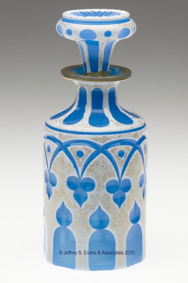 CUT OVERLAY MOORISH WINDOW COLOGNE BOTTLE: CUT OVERLAY MOORISH WINDOW COLOGNE BOTTLE, opaque white to translucent starch blue with gilt decorations, cylindrical form with a short neck, flanged mouth, and factory polished lip and pontil mark, o