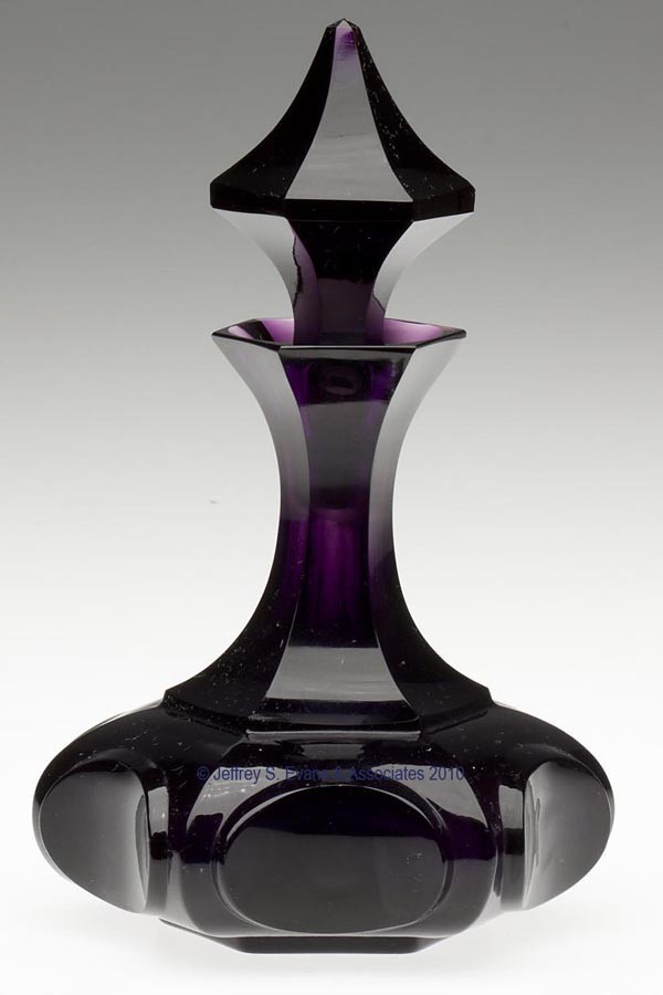 BLOWN-MOLDED PANELED HORIZONTAL OVALS COLOGNE BOTT: BLOWN-MOLDED PANELED HORIZONTAL OVALS COLOGNE BOTTLE, brilliant deep amethyst, large-size hexagonal form with panel-cut neck, factory polished lip, ovals, table ring, and pontil mark, original hexagon
