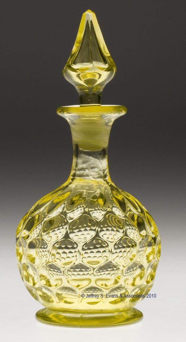 BLOWN-MOLDED BABY THUMBPRINT COLOGNE BOTTLE: BLOWN-MOLDED BABY THUMBPRINT COLOGNE BOTTLE, canary yellow, bulbous form with five rows of thumbprints, medium plain neck, and flanged mouth, raised on a circular foot with a polished pontil mark, ori