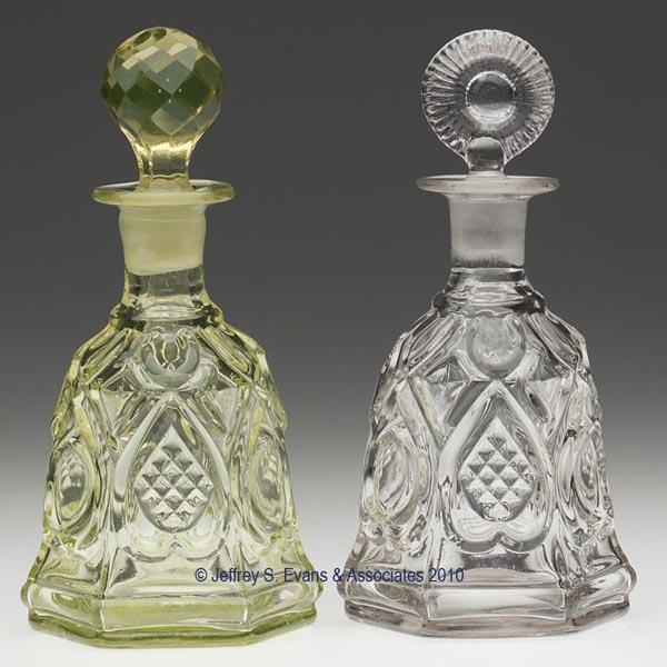 TWO BLOWN-MOLDED HEART COLOGNE BOTTLES: TWO BLOWN-MOLDED HEART COLOGNE BOTTLES, canary yellow and colorless, each of hexagonal form with a short neck, flanged lip, and polished pontil mark, well-fitting but inappropriate stoppers. Bottles p
