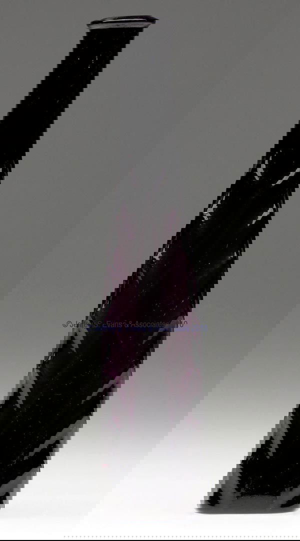 BLOWN-MOLDED HERRINGBONE COMMERCIAL COLOGNE BOTTLE: BLOWN-MOLDED HERRINGBONE COMMERCIAL COLOGNE BOTTLE, deep amethyst, obelisk form with heavy herringbone-edge corners, plain arched panels, tooled mouth, and plain base. Possibly Boston & Sandwich Glass