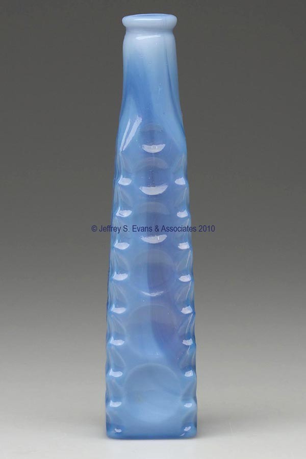 BLOWN-MOLDED HERRINGBONE AND THUMBPRINT COMMERCIAL: BLOWN-MOLDED HERRINGBONE AND THUMBPRINT COMMERCIAL COLOGNE BOTTLE, fiery opalescent powder blue, obelisk form with heavy herringbone-edge corners, three panels with six graduated thumbprints, one pane