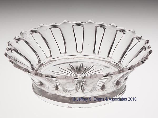 PRESSED OPEN-WORK BASKET: PRESSED OPEN-WORK BASKET, colorless, shallow bowl with a 32-point rim above 16 vertical staves, base with a 34-point star centering a small rough pontil mark. Boston & Sandwich Glass Co. 1829-1850. 2 