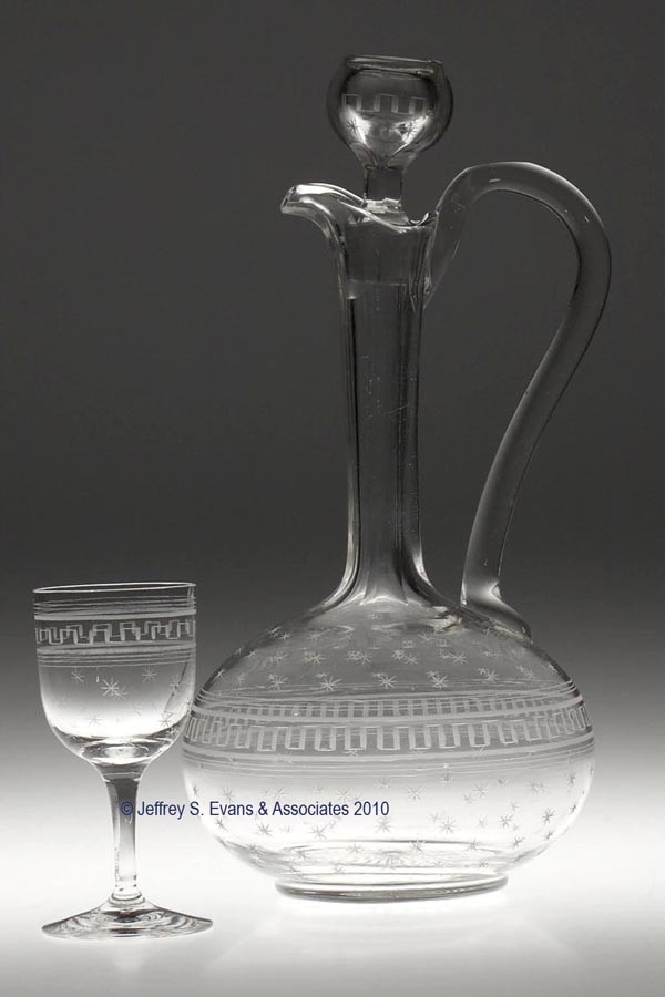LATE BLOWN AND ENGRAVED ROMAN KEY AND STAR CLARET : LATE BLOWN AND ENGRAVED ROMAN KEY AND STAR CLARET SET, colorless, comprising a decanter with applied handle and original stopper, and eight glasses. Probably Boston & Sandwich Glass Co. 1870-1887. 11 