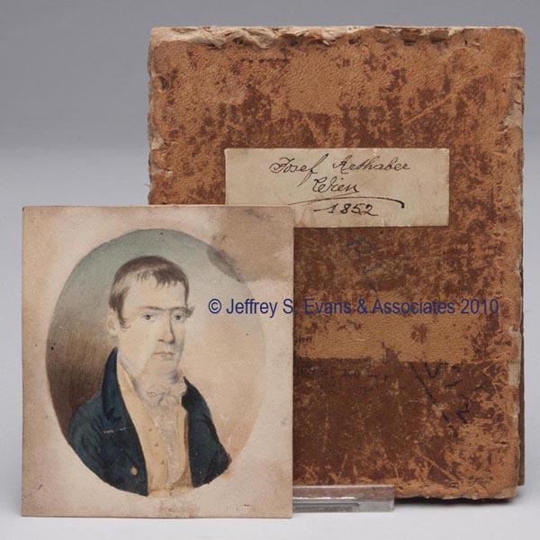 UNIDENTIFIED MINIATURE PORTRAIT OF A GENTLEMAN: UNIDENTIFIED MINIATURE PORTRAIT OF A GENTLEMAN watercolor on paper, the subject dressed in a blue coat with yellow vest. Not framed, with a leather-covered board labeled Josef Arthaber Crim 1852. 1830