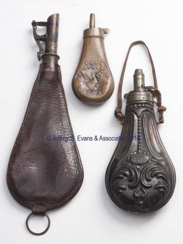 THREE ASSORTED SHOT POUCHES: THREE ASSORTED SHOT POUCHES comprising a small copper example with an American eagle, a larger copper example marked for Powell & Son, Cincinnati, O, and a leather example. 19th century. 4 3/4" to 10"